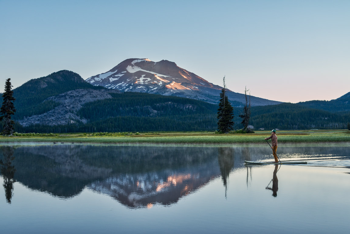 person on paddle board on Sparks Lake reflecting South Sister Mountain in Central Oregon