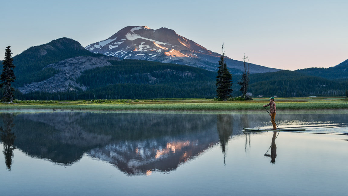 person on paddle board on Sparks Lake reflecting South Sister Mountain in Central Oregon